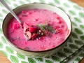 Pyszna zupa z botwiny z ziemniakami osobno, podana w misce z łyżką i ozdobiona koperkiem.
