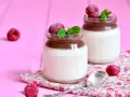 Två glas med choklad- och vaniljpannacotta, toppade med hallon och mynta. Perfekt som dessertvin till pannacotta.