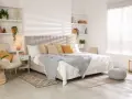 Dormitorios cálidos y acogedores con cama grande, sillón cómodo, plantas y estanterías decoradas.