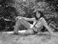 Nadia Cassini, con il suo fisico prorompente, posa su un prato, sfoggiando un completo giacca e pantaloni.