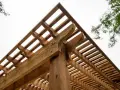Drewniana pergola z ozdobnymi wspornikami. Dowiedz się, jak wysuszyć mokre drewno konstrukcyjne, aby służyło latami.