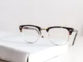 Okulary z oprawkami w stylu clubmaster leżą na białej książce. Czy wada 0.75 to powód, by nosić okulary?