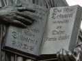 Hände halten ein aufgeschlagenes Buch mit Luthers Übersetzung des Neuen Testaments. Die Bedeutung der Reformation wird durch diese Darstellung greifbar.