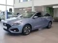 Niebieski Hyundai i30 Wagon z 2015 roku stoi w salonie samochodowym.