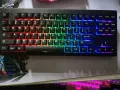 Eine schwarze Tastatur mit bunter RGB-Beleuchtung, die wie ein Regenbogen verstellt ist. Die Tasten leuchten in Rot, Orange, Gelb, Grün, Blau und Violett.
