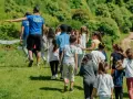 Un groupe d'enfants suit un coach sur une colline verdoyante. Ces actions pour financer un voyage scolaire sont pleines d'énergie et de joie.