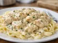Pyszny keto kurczak w sosie śmietanowym na tagliatelle, posypany natką pietruszki. Idealny na lekki obiad.