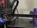 Głowica drukująca klipper ender 3 z kablem w oplocie. Na półce w tle fioletowa puszka z napisem "aussie".