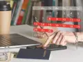 Planowanie urlopu zgodnie z kodeksem pracy. Na biurku laptop, paszport, pieniądze i kalendarz z zaznaczonymi dniami.