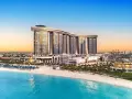 Luksusowy Rixos Premium Alamein z widokiem na turkusowe morze i piaszczystą plażę. Idealne miejsce na wakacje.