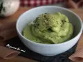 Una ciotola bianca piena di vellutata crema di avocado, cosparsa di pepe nero macinato. Accanto, pasta integrale.