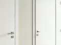 Dwie białe drzwi, jedna przylgowe, druga bezprzylgowe, z metalowymi klamkami.