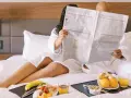 Para czyta gazetę w łóżku, delektując się śniadaniem. To idealny poranek w B&B, gdzie "co to znaczy" to po prostu komfort i spokój.