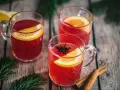Drei Tassen Kinderpunsch mit Orangenscheiben und Sternanis. Die ideale Temperatur für den Punsch ist warm und einladend.
