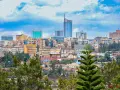 Widok na miasto z kigali, z górującymi budynkami i zielenią.