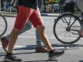 Ludzie idą i jadą na rowerze po mieście. Czy jazda na rowerze odchudza brzuch? Aktywność fizyczna pomaga spalać kalorie.