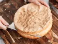 En person skär en fluffig sockerkaksbotten med en kniv. Perfekt för ditt nästa cake recept!