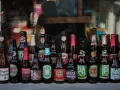 Rząd butelek z piwem kraftowym, w tym Trappistes Rochefort, Chimay, Goose Island i inne. Idealne na pytanie: jakie piwo kraftowe wybrać?