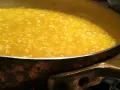 Un cremoso risotto alla milanese che sobbolle in una pentola di rame, pronto per essere gustato.