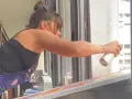 Une artiste applique du vernis sur sa peinture acrylique colorée, protégeant ainsi son œuvre.