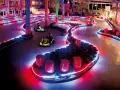 Tor kartingowy w stylu Canpol Wonderland, oświetlony neonami, z gokartami w akcji.