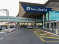Wejście do Terminalu 3 lotniska Fiumicino z drogą dojazdową i samochodami.
