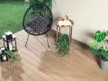 Drewno kompozytowe to świetny pomysł, czym wyłożyć balkon. Wygodne krzesło, stolik i rośliny tworzą przytulną przestrzeń.