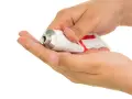 Dłoń wyciska maść clobederm na drugą dłoń.