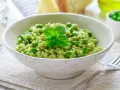 Un cremoso risotto con piselli, guarnito con menta fresca. Un piatto primaverile che celebra il gusto del riso e piselli.