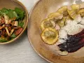 Ravioli pasta mit Trüffeln, Parmesan und einer dunklen Sauce. Daneben eine Schüssel mit Pilzen, Nüssen und Spinat.