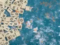 Fichas de letras de madera esparcidas, algunas formando palabras con w, sobre un fondo azul texturizado con salpicaduras blancas y naranjas.