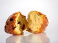Frittelle veneziane, dolci e soffici, con uvetta e zucchero, spezzate a metà per mostrare l'interno invitante.