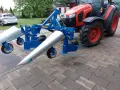 Niebieska kosiarka do fasoli marki SOCHMET, zamontowana z tyłu czerwnego traktora Kubota, gotowa do pracy na polu.