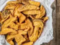 Un cesto pieno di croccanti funghi fritti, cosparsi di sale grosso, pronti per essere gustati.