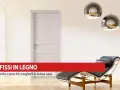 Infissi in legno: pro e contro per la tua casa. Porta bianca, chaise longue e lampade moderne in un ambiente luminoso.