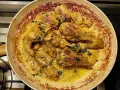 Pollo alla Marengo succulento in padella, dorato e profumato, con erbe fresche tritate.