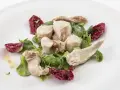 Delicato tonno di coniglio servito con insalata fresca e radicchio croccante, condito con olio d'oliva.