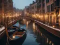 Gondole ferme in un canale di Venezia a dicembre, con luci soffuse e un ponte sullo sfondo.