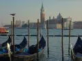 Gondole czekają na turystów na weneckiej trasie. W tle kościół San Giorgio Maggiore.
