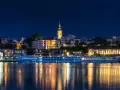 Nocny Belgrad z rzeką i statkiem wycieczkowym. Czy do Serbii potrzebny jest paszport? Sprawdź przed podróżą!