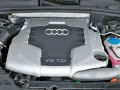 Silnik V6 TDI Audi z widocznym logo i oznaczeniem pojemności. Widać elementy układu dolotowego i płyny eksploatacyjne.