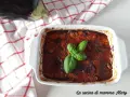 Parmigiana di melanzane non fritte, appena sfornata, guarnita con basilico fresco. La ricetta perfetta per un piatto leggero e gustoso.