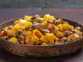 Un delicioso salteado de setas y patatas doradas en un cuenco de madera.