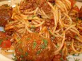 Pyszne spaghetti z pulpetami w sosie pomidorowym, posypane natką pietruszki. Klasyczne danie, które zawsze smakuje wyśmienicie.