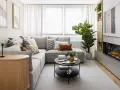 Sofá gris, mesa de centro negra, chimenea moderna y mueble de madera. Una sala acogedora, perfecta para una reforma sin obras.