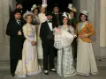 Un gruppo di persone in abiti d'epoca, con un neonato in braccio, anticipazioni una vita di famiglia e tradizione.