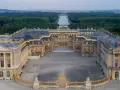 Le château de Versailles, construit par Louis XIV, s'étend majestueusement avec ses cours pavées et ses jardins.