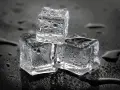 Drei eiswürfel mit Wassertropfen auf schwarzem Hintergrund. Die Frage, wie lange braucht Eis zum Gefrieren, wird hier visuell beantwortet.