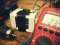 Narzędzia i transformator, potencjalne odpady elektroniczne, czekają na diagnozę multimetrem.