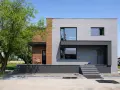 Nowoczesne elewacje domów z lat 70-tych, z betonowych bloków i drewna, z dużymi oknami i tarasem.